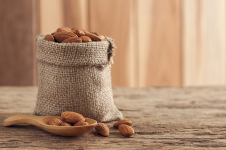 Almonds seeds, Almonds in sack on wooden tableの写真素材
