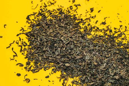 large leaf green tea scattered on a yellow background. close-up. macroの写真素材