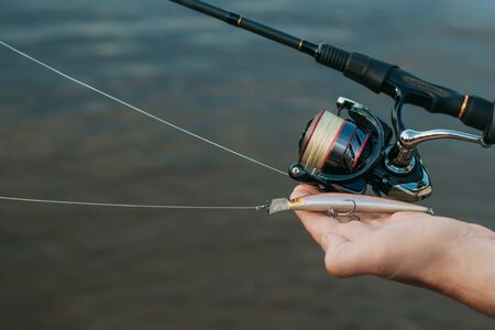 Fishing in river.A fisherman with a fishing rod on the river bank. Man fisherman catches a fish.Fishing, spinning reel, fish. The concept of a rural getaway. Article about fishingの写真素材