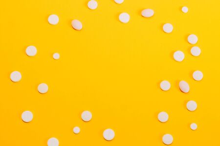 Different pills and vitamins are scattered on a yellow background. space for text, closeupの写真素材