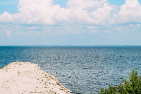 landscape of the river. curly clouds over the horizon. blue water surfaceの写真素材