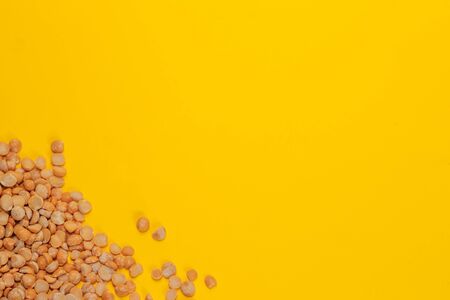 dry red peas scattered on a yellow background close-up. place for text. Textureの写真素材