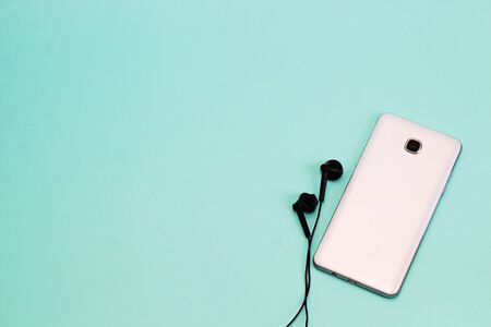 View from above. white phone and black headphones on a light backgroundの写真素材