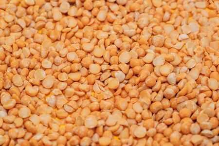 dry red peas scattered on a yellow background close-up. place for text. Textureの写真素材