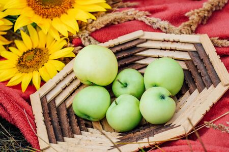 still life sunflowers and green apples in a basket. Close-upの写真素材