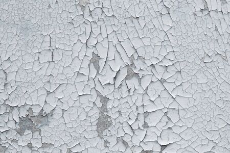 rough background for designers. The texture of the old cracked white paint. Old broken paint on a concrete wall.の写真素材