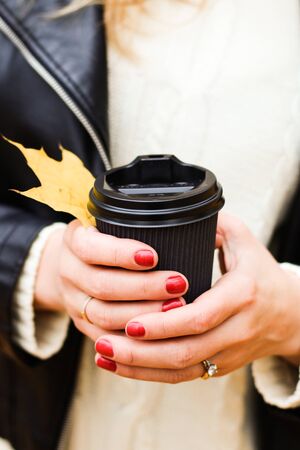 A glass of coffee in the hands of a girlの写真素材