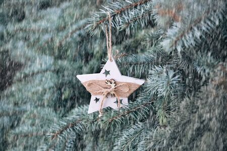 Christmas toy on the branches of a New Year tree. Christmas tree decorated with wooden handmade toysの写真素材