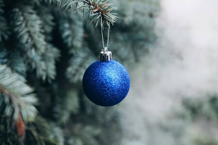 Christmas toy on the branches of a New Year tree. Christmas tree decorated with a festive ballの写真素材
