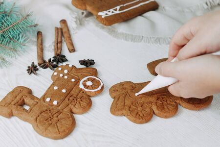Christmas gingerbread cookies painted with icing sugar. Confectioner girl paints cookiesの写真素材
