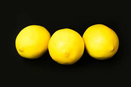 three lemons on a black backgroundの写真素材