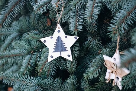 Christmas toy on the branches of a New Year tree. Christmas tree decorated with wooden handmade toysの写真素材