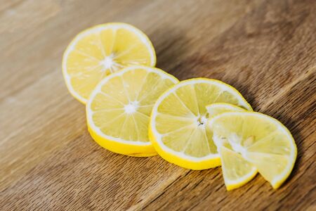 lemon slices neatly cut and lie on a wooden background. space for textの写真素材