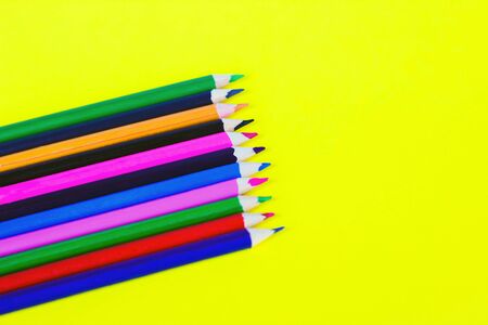 color pencils on a yellow background, background for designers, space for textの写真素材