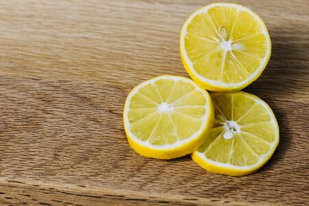 lemon slices neatly cut and lie on a wooden background. space for textの写真素材
