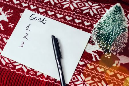 goals written on a sheet with notepad on a background with Christmas symbolsの写真素材