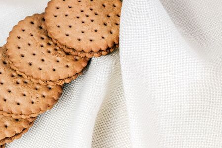 Crispy chocolate cinnamon with holes on a wooden board. Round biscuits with filling. space for textの写真素材