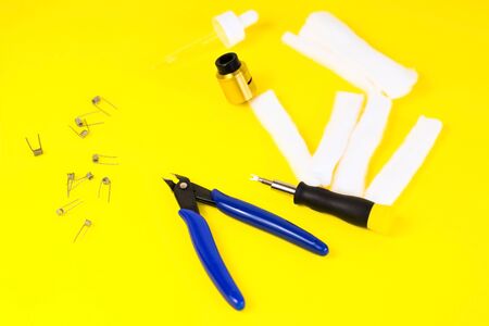 electronic cigarette details, Vata, coils, drip, spring, nippers on a yellow background. flat lay vapeの写真素材