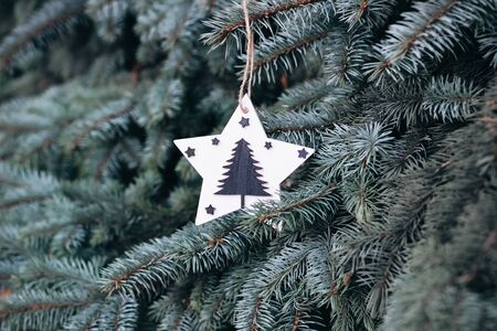 Christmas toy on the branches of a New Year tree. Christmas tree decorated with wooden handmade toysの写真素材