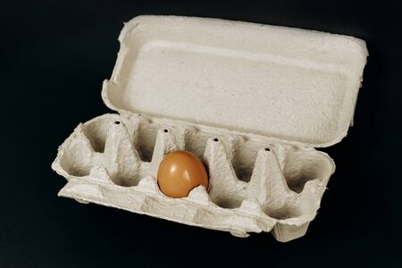 chicken eggs in a paper gray crate on a black backgroundの写真素材
