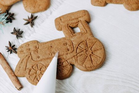 Christmas gingerbread cookies in the shape of a steam train. Cornet is filled with sugar icing to decorate cookiesの写真素材