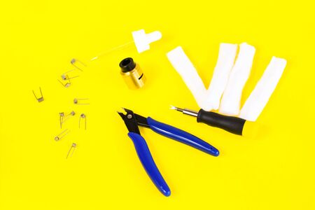 electronic cigarette details, Vata, coils, drip, spring, nippers on a yellow background. flat lay vapeの写真素材