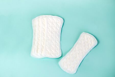 flat lay of feminine hygiene items. Details for critical women's days on a turquoise background. Gaskets for women, healthの写真素材