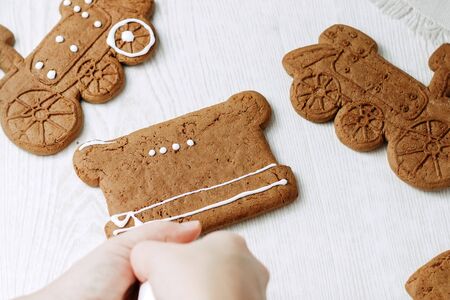 Christmas gingerbread cookies painted with icing sugar. Confectioner girl paints cookiesの写真素材
