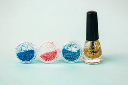 manicure flat on a turquoise background. glitters for manicure or makeup designの写真素材