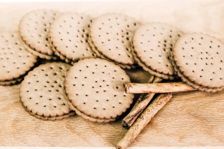 Crispy chocolate cinnamon with holes on a wooden board. Filled Round Cookiesの写真素材
