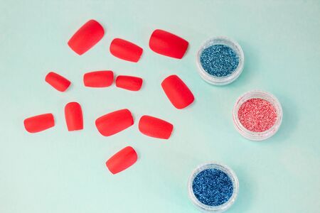 manicure flat on a turquoise background. glitters for manicure or makeup design, false nailsの写真素材