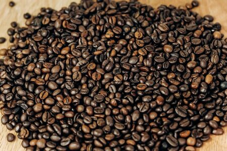 a lot of coffee beans on a wooden background. background and space for textの写真素材
