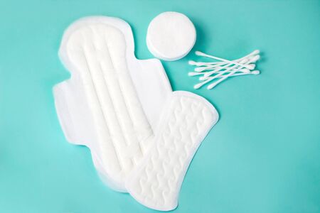 flat lay of feminine hygiene items. Details for critical women's days on a turquoise background. Gaskets for women, healthの写真素材