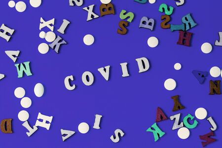 The wooden letters are the word covid. Concept on the theme of flu, virus.の写真素材