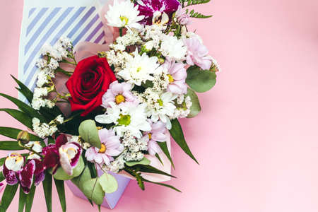 Box in the form of an envelope with a bouquet of flowers. Orchids, greenery, chrysanthemums and rose.の写真素材