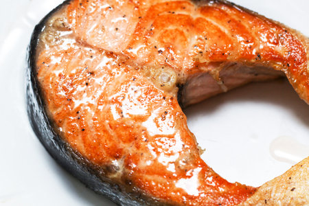 Cooked appetizing salmon steak on a snow-white plate. Close-up.の写真素材