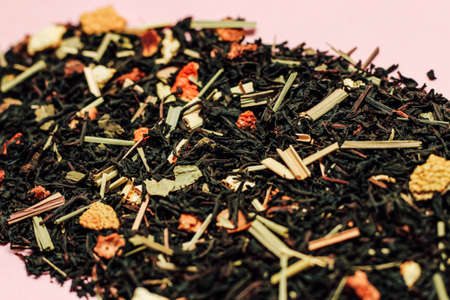 Loose black tea with dried fruit pieces, orange peel and lemon grass close upの写真素材