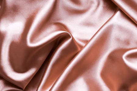 Pink powdery nude silk background, satin fabric backdrop. Pleated fabric.の写真素材