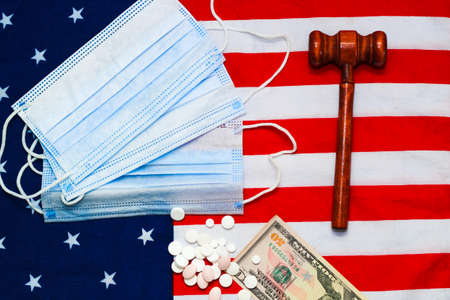Judge gavel with money and pills on the background of the USA flag.の写真素材