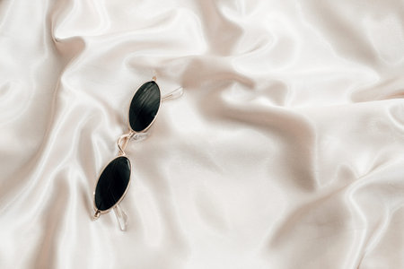 Sunglasses in gold frames on a background of silk. Flatley.の写真素材