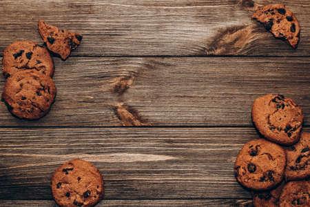 Chocolate aromatic cookies with pieces of cocoa flatley on a background of wooden boards.の写真素材
