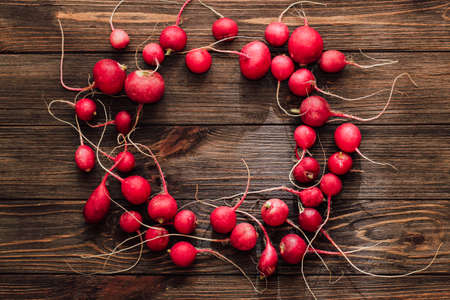 red fresh radish circle top view on wooden planks background.の写真素材