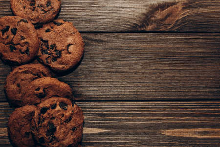 Chocolate aromatic cookies with pieces of cocoa top view on a background of wooden boards.の写真素材