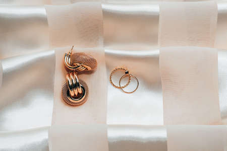 Women's jewelry earrings, trendy jewelry, rings on a silk background.の写真素材