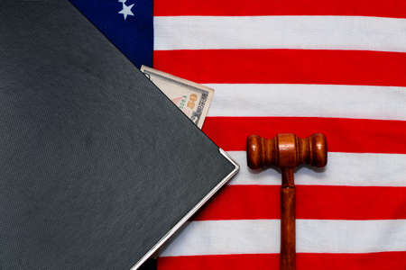 Judge gavel with documents and money on the background of the USA flag.の写真素材