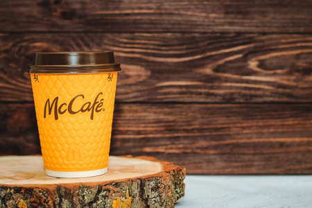 Ukraine, Cherkasy May 16, 2021 - Yellow glass with coffee from McDonald's on a wooden background.のeditorial素材