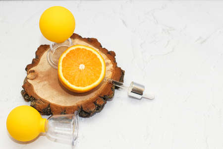 Vacuum massage anti-cellulite cups on a gray background with orange and oil. Self-massage for healthy skin.の写真素材