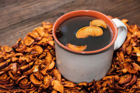 Dried apple slices close up, useful vitamins for drinks in a healthy diet. Cup with uzvar.の写真素材