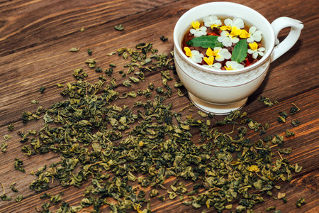 A beautiful white cup with a gold border decorated with flowers, herbal green healthy tea. Business account design.の写真素材
