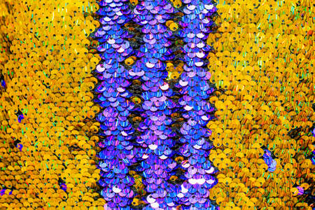 The shiny bright texture of the sequins changes color. Purple and yellow. Fabric for fancy dresses.の写真素材